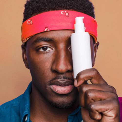 image of man with red bandana holding a white cosmetic bottle